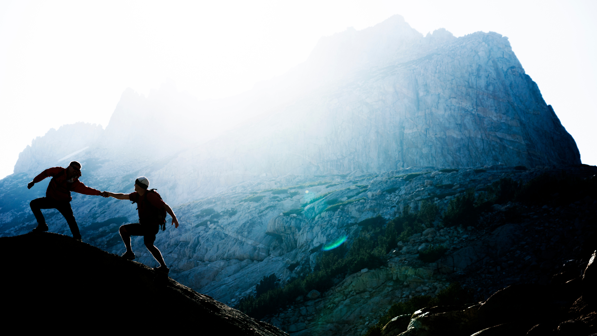 Two climbers ascending a mountain together — navigating the terrain side by side